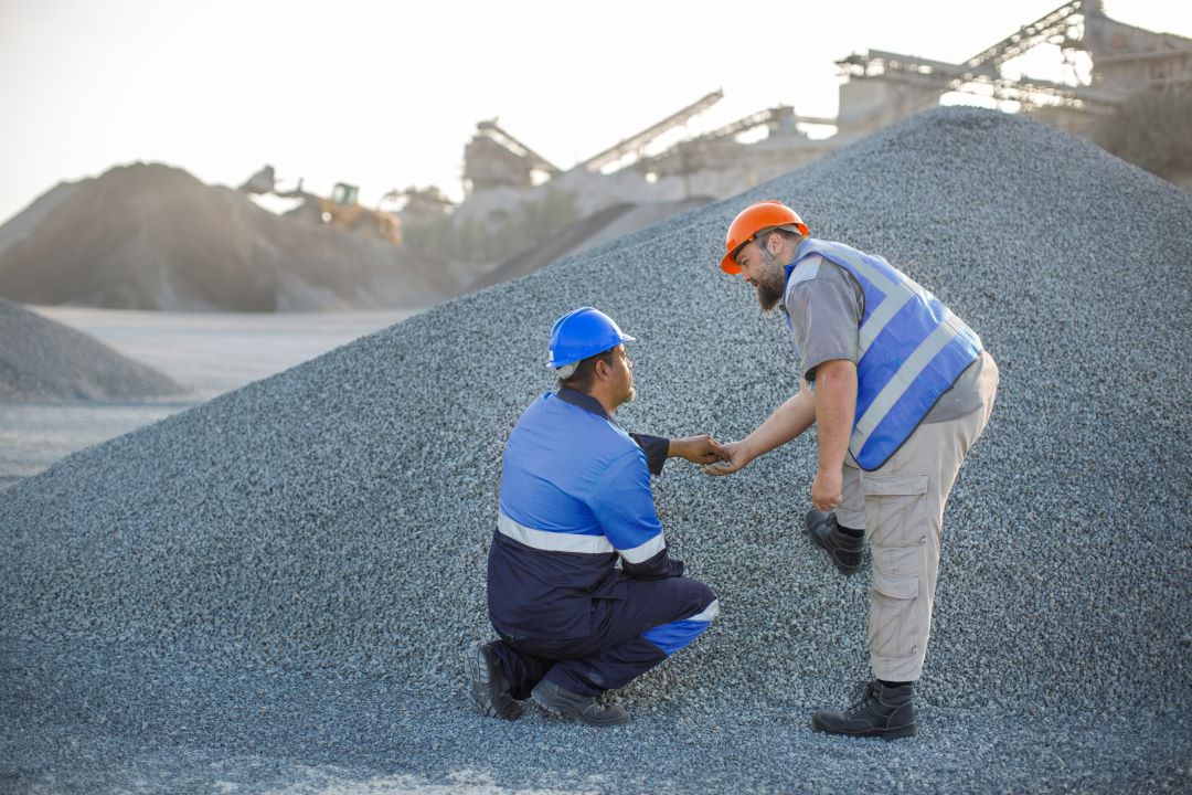 what is subbase made of, two construction workers checking out aggregate quality in a quarry