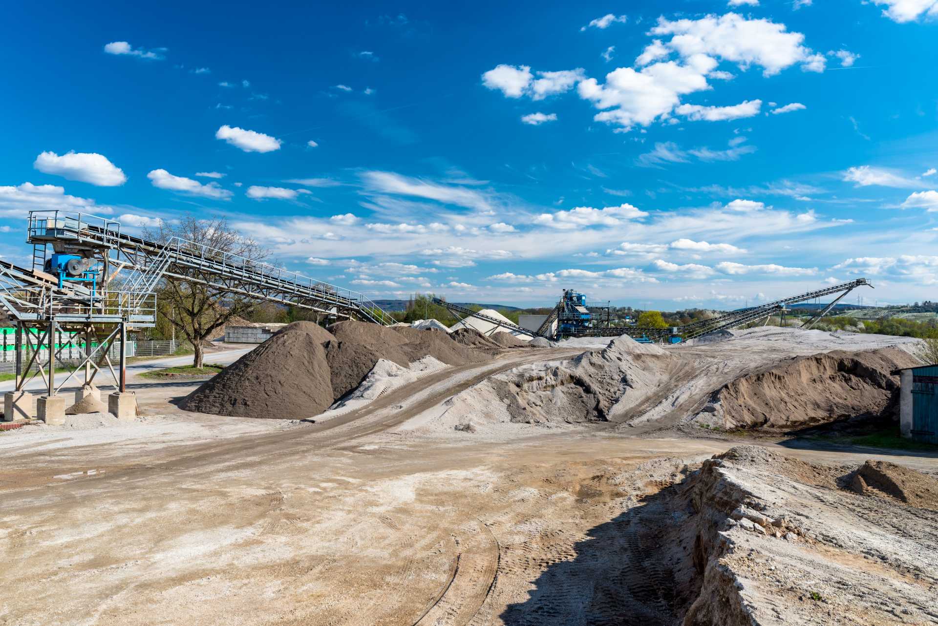aggregates for net zero projects, A quarry site with heaps of sand and crushed gravel.