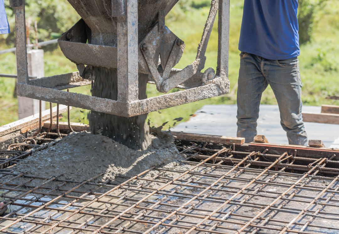 ready mix concrete supplier checklist, construction worker pouring cement on a fence frame using a cement cement tank bucket