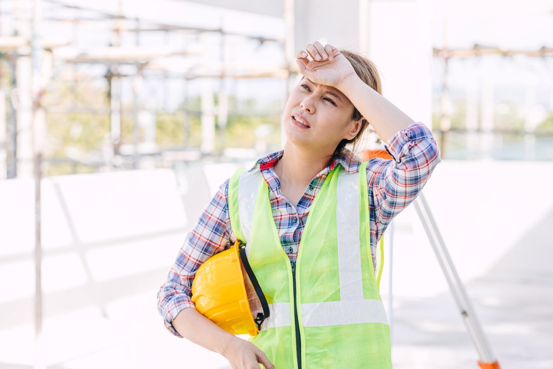 summer construction, a construction worker looking tired in the summer heat