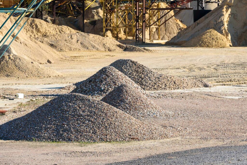 aggregate sourcing regulations, Piles of sand and gravel on a construction site.